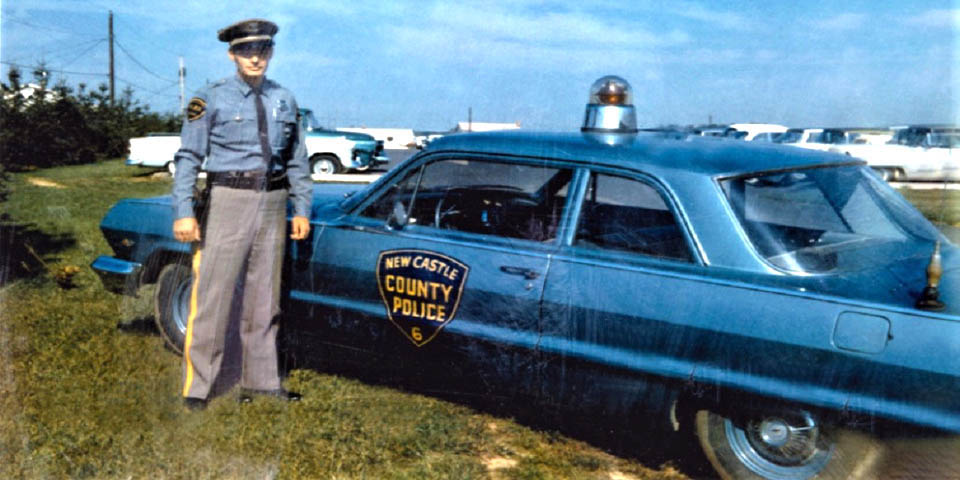 Officer Earl Biddle behind the Old County Headquarters building on Kirkwood Hwy in Newark Delaware 1960s